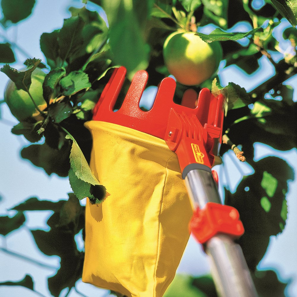WOLF-Garten RGM Multi-Change® Fruit Picker with red and yellow 13cm head, adjustable angle, built-in blade and cotton bag, shown picking an apple from a tree