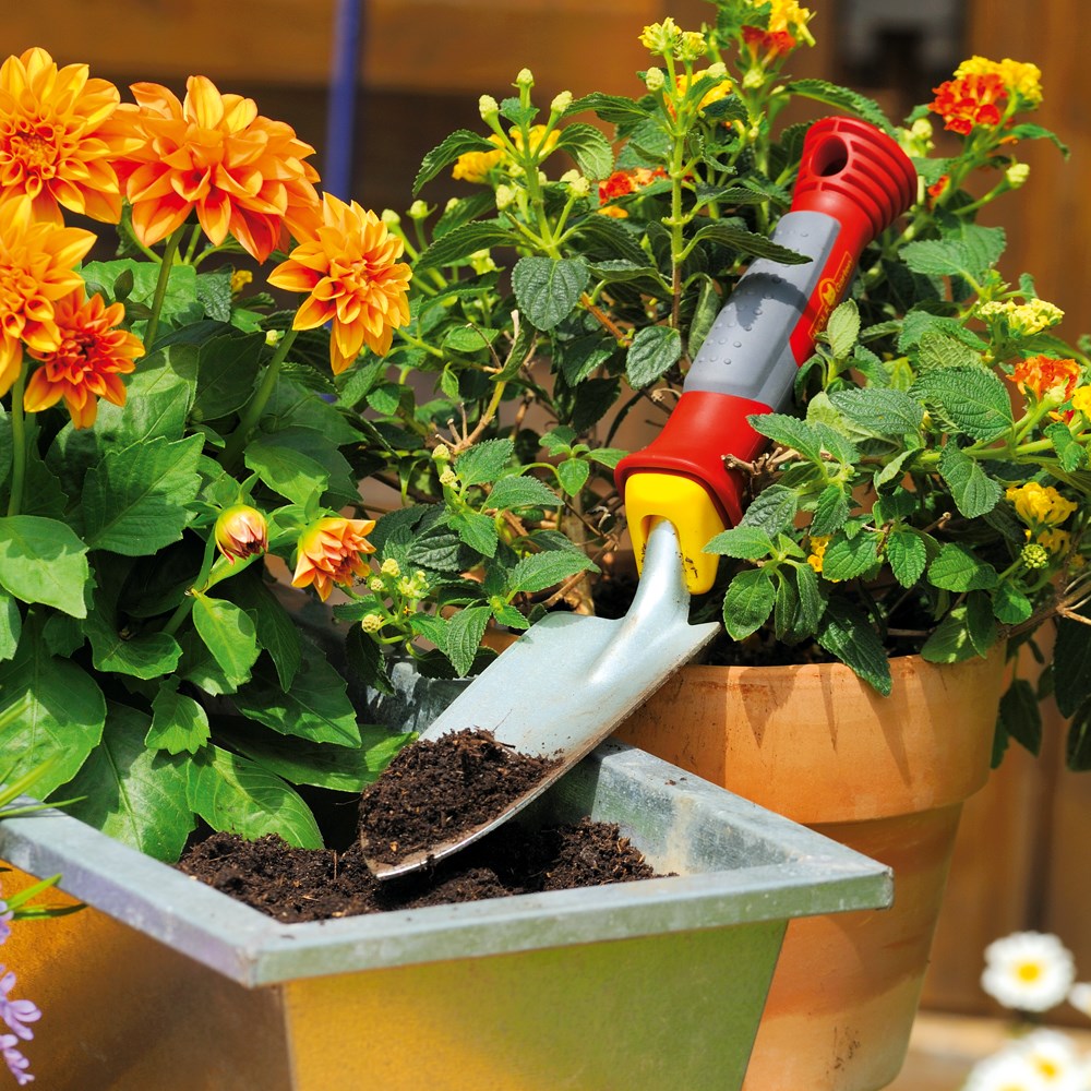 WOLF-Garten LU2P Multi-Change® Planting Trowel with red and yellow 7cm steel head and pointed blade, shown in a flower pot