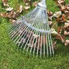Close-up of UAM rake head attached to a telescopic handle, flexible tines gliding over grass and scattered leaves