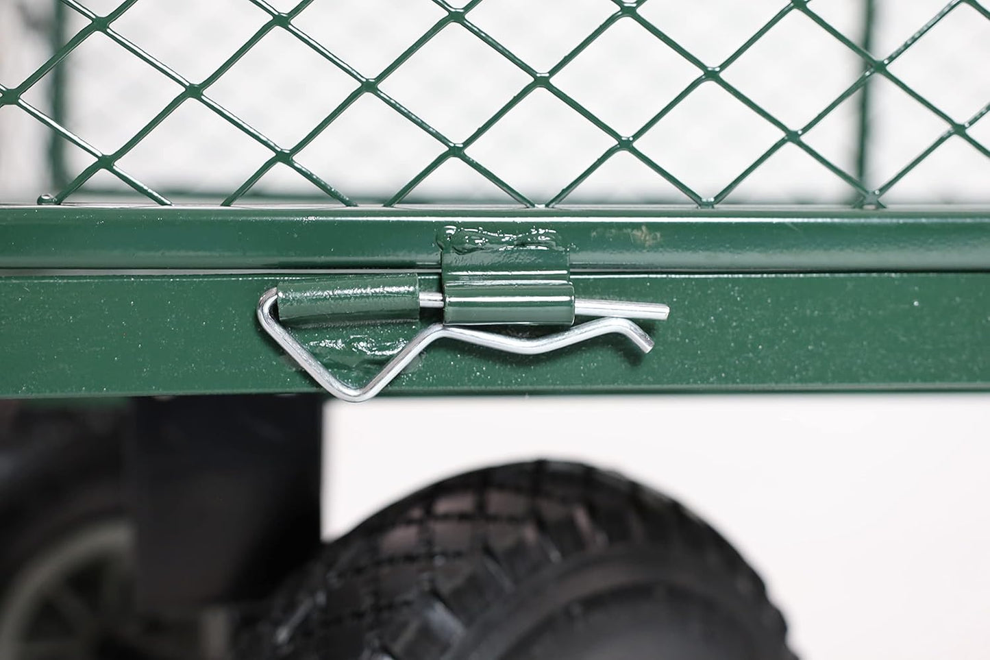 Close-up of a green metal gate with a handle, blurred background