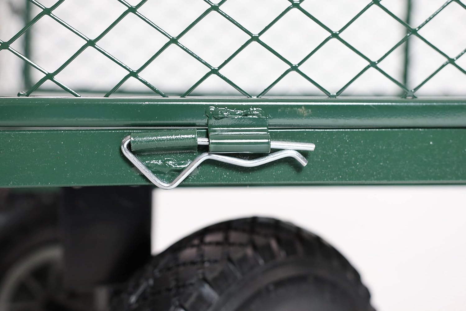Close-up of a green metal gate with a handle, blurred background