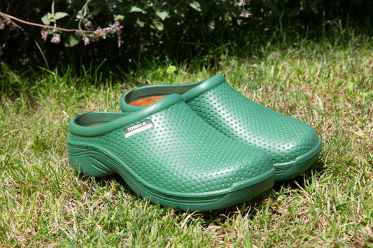 Pair of green clogs or cloggies on grass
